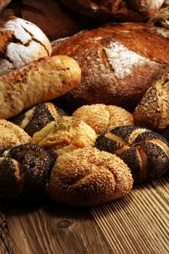 Different kinds of bread and bread rolls on board from above. Kitchen or bake Stock Photos
