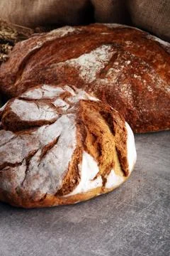 Different kinds of bread and bread rolls on board from above. Kitchen or bake Stock Photos