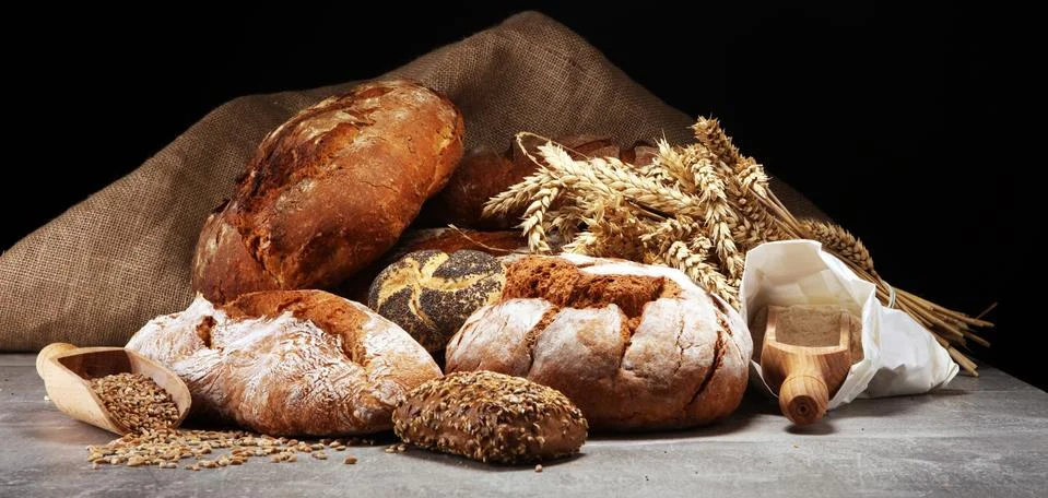 Different kinds of bread and bread rolls on board from above. Kitchen or bake Stock Photos