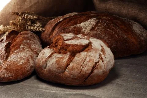Different kinds of bread and bread rolls on board from above. Kitchen or bake Stock Photos
