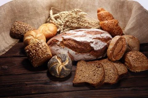 Different kinds of bread and bread rolls on board from above. Stock Photos
