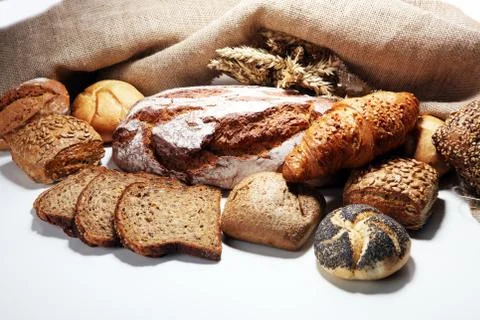 Different kinds of bread and bread rolls on board from above. Stock Photos