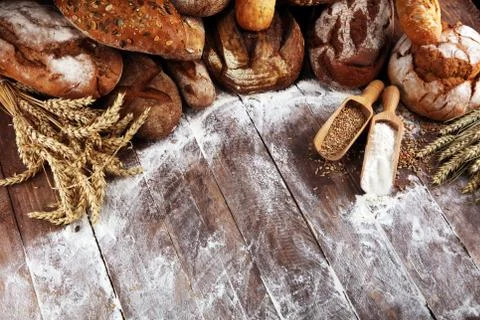Different kinds of bread and bread rolls on board from above. Kitchen or bake Stock Photos