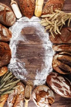 Different kinds of bread and bread rolls on board from above. Kitchen or bake Stock Photos