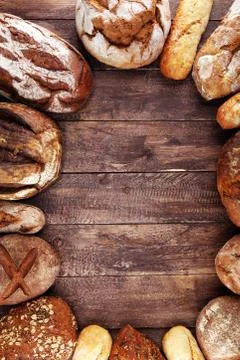 Different kinds of bread and bread rolls on board from above. Kitchen or bake Stock Photos