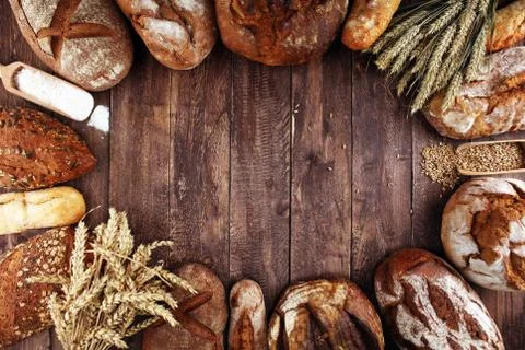 Different kinds of bread and bread rolls on board from above. Kitchen or bake Stock Photos