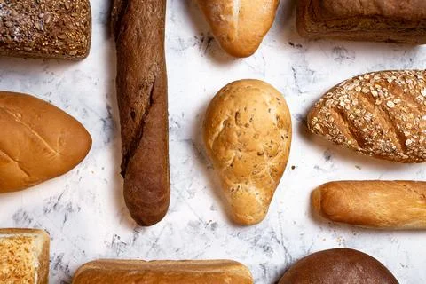 Different kinds of bread, top view, bright background Stock Photos