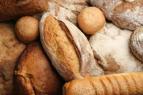 Different kinds of delicious bread as background, top view Stock Photos