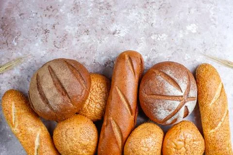 Different kinds of fresh bread as background, top view Stock Photos