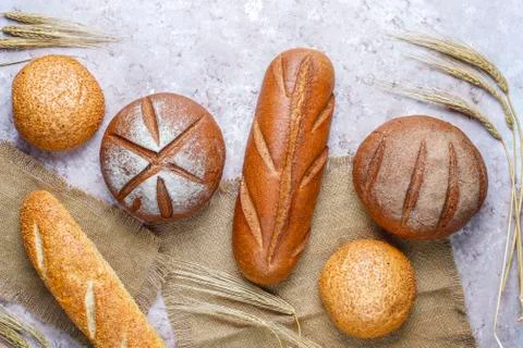 Different kinds of fresh bread as background, top view Stock Photos