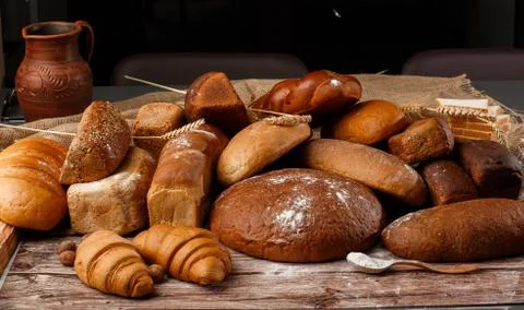 Different kinds of fresh bread as background, top view. Bakery gold rustic cr Stock Photos