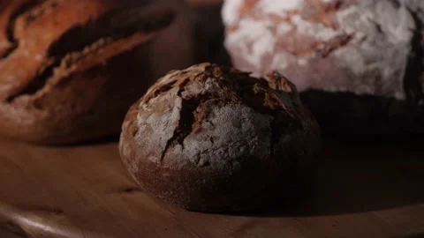 Different kinds of fresh self-made bread and buns on a wooden plate. Stock Footage 145973367