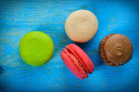 Different kinds of macaroons in stack on wooden background Stock Photos