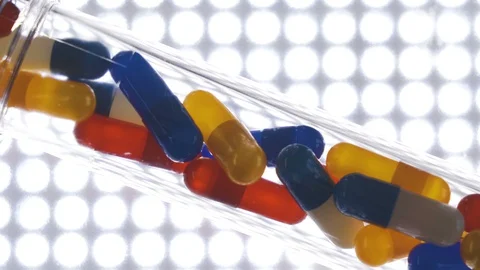 Different kinds of the medicine capsules inside the glass tube Stock Footage 129343213