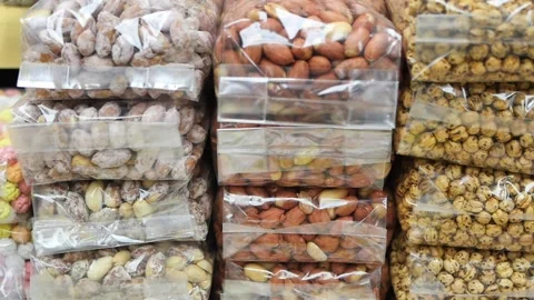 Different kinds of nuts in clear plastic bags at a store Stock Footage 340497058