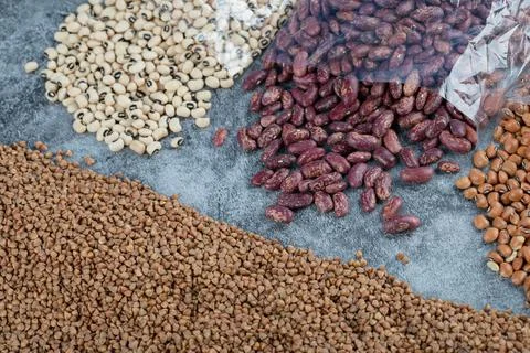 Different kinds of raw beans on a marble background Stock Photos
