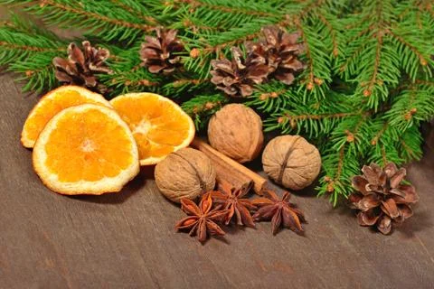 Different kinds of spices, nuts, dried oranges, cones and spruse branch Stock Photos
