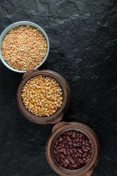 Different kinds of uncooked beans on ancient pots Stock Photos