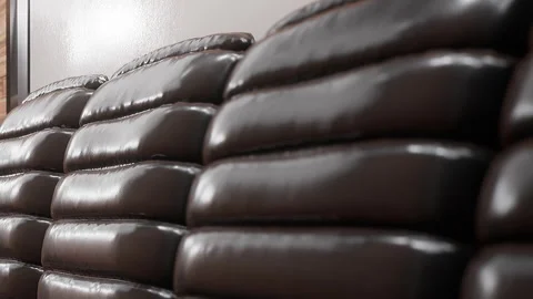 Different layers of brown cushions stacked along a wall in a room Stock Footage 344997394
