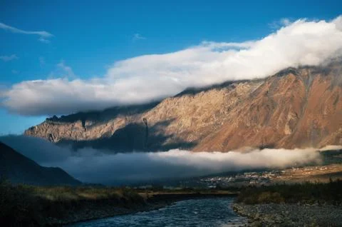 Different layers of clouds over Stepantsminda village and mountain, Georgia. Stock Photos