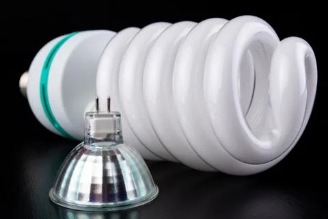 Different light bulbs and fluorescent lights on a wooden table. New types of  Stock Photos