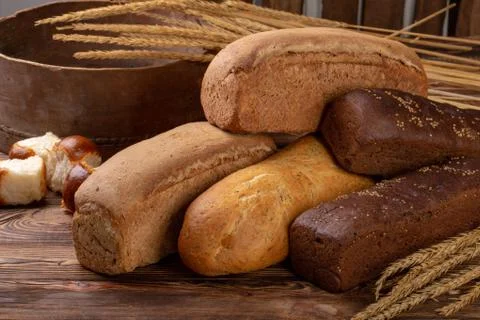 Different loaves of bread with wheat of spikelets Foto stock