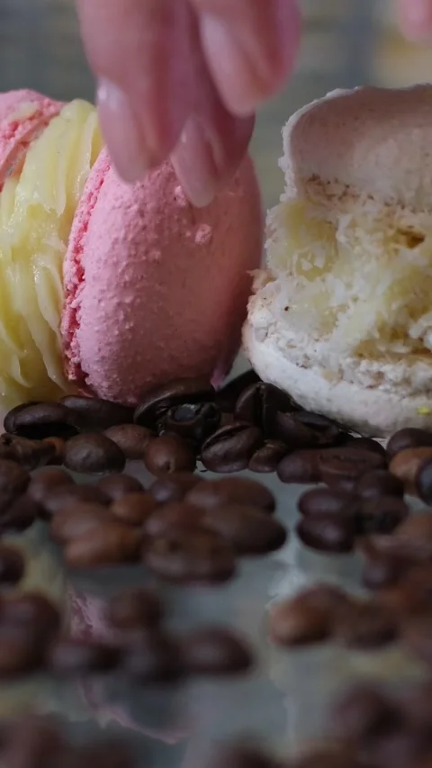 Different macaroons lie on the glass table female hands pick up French dessert a Stock Footage 251226207