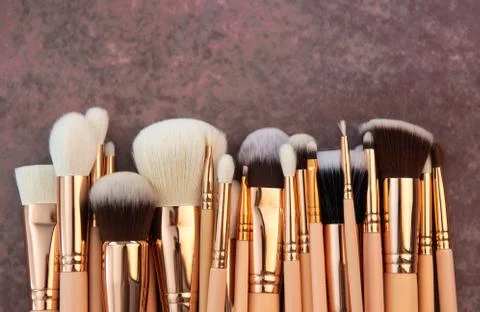 Different makeup brushes on a brown background Stock Photos