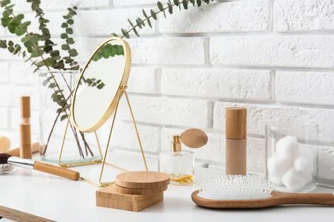 Different makeup products with mirror and eucalyptus branches on white table  Stock Photos