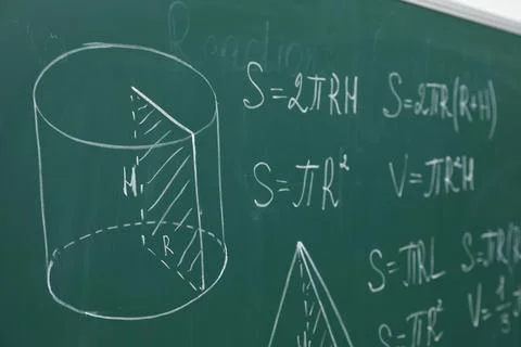 Different math formulas written with chalk on green board Stock Photos