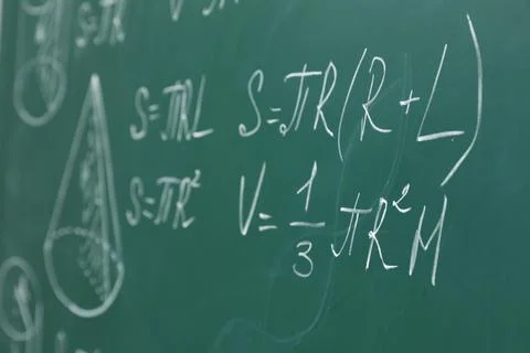 Different math formulas written with chalk on green board Stock Photos