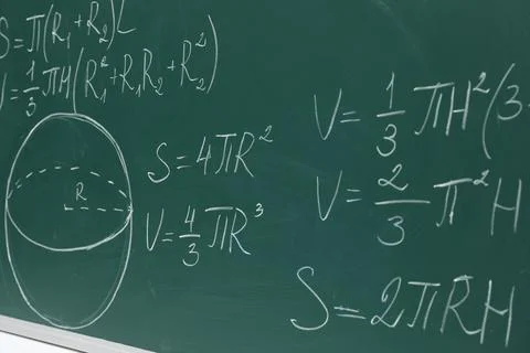 Different math formulas written with chalk on green board Stock Photos