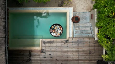 Different meals for breakfast or lunch on floating tray in swimming pool at Stock Footage 243166567