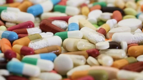 Different medication pills spinning through closeup view Stock Footage 97823256