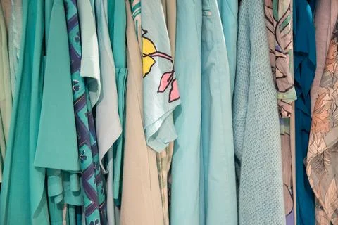 Different models blue beige blouses in second hand store on a hanger Stock Photos