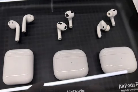 Different models of wireless earbuds displayed in an electronic store Stock Photos