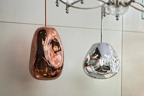 Different modern streamlined mirror copper chandeliers. Metal copper shaped p Stock Photos