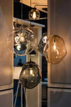 Different modern streamlined mirror glass chandeliers. Bubble transparent, me Stock Photos