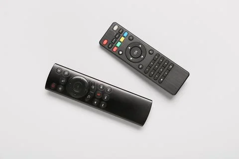 Different modern TV remote controls on grey background Stock Photos
