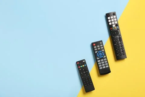 Different modern TV remote controls on color background Stock Photos