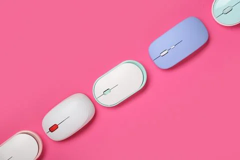 Different modern wireless computer mouse devices on pink background Stock Photos