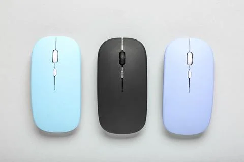Different modern wireless computer mouse devices on grey background Stock Photos