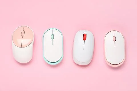 Different modern wireless computer mouse devices on pink background Stock Photos