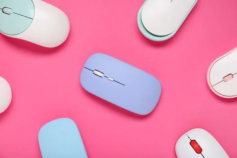 Different modern wireless computer mouse devices on pink background Stock Photos