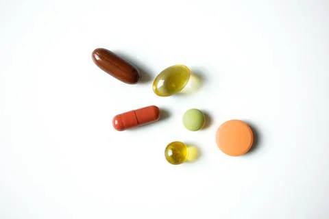 Different multicolored pills, tablets, vitamins, capsules isolated on white.. Stock Photos