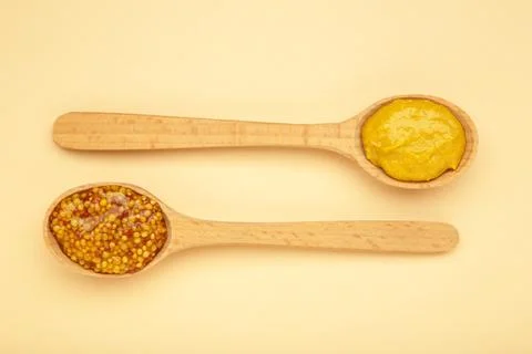 Different mustard in spoon on beige background with clipping path. Stock Photos
