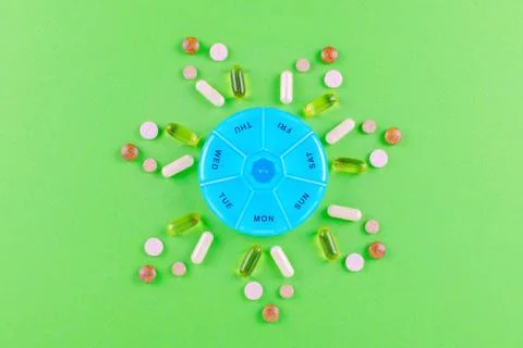 Different nutritional supplements for one week and a pills box on green Stock Photos