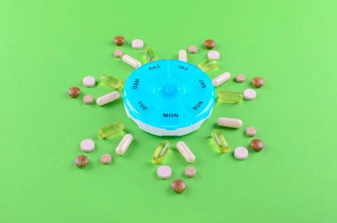 Different nutritional supplements for one week and a pills box on green Stock Photos