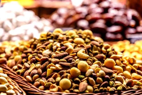 Different nuts: almonds, pistachios, hazelnuts, are on the counter on the mar Stock Photos