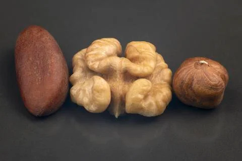 Different nuts close-up on a gray background. Healthy food and vitamins. Stock Photos